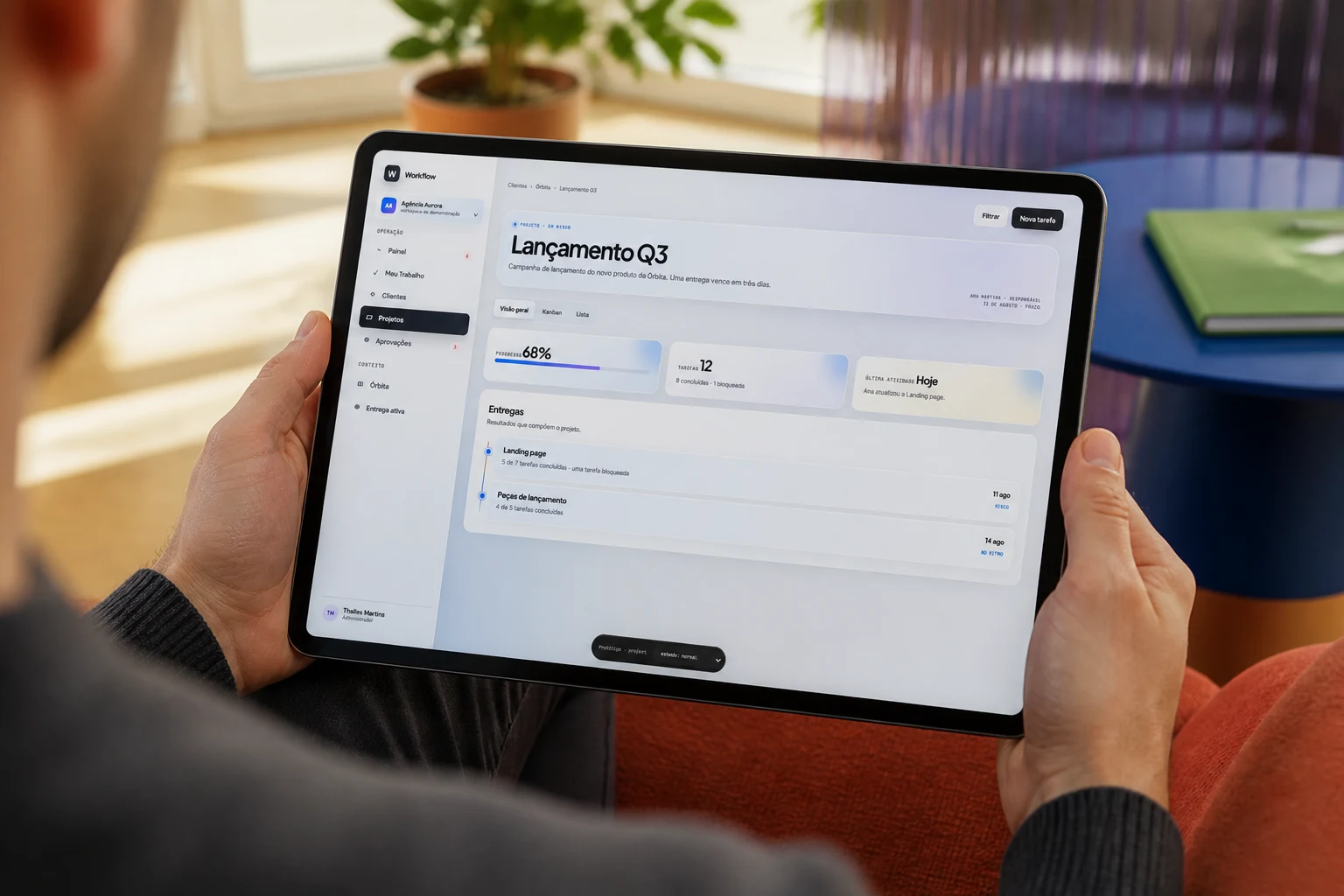 Pessoa em uma composição conceitual revisando a tela real de projeto do Workflow em um tablet.